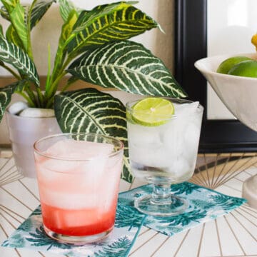 Two ingredient drinks on napkins on white table.