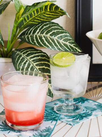 Two ingredient drinks on napkins on white table.