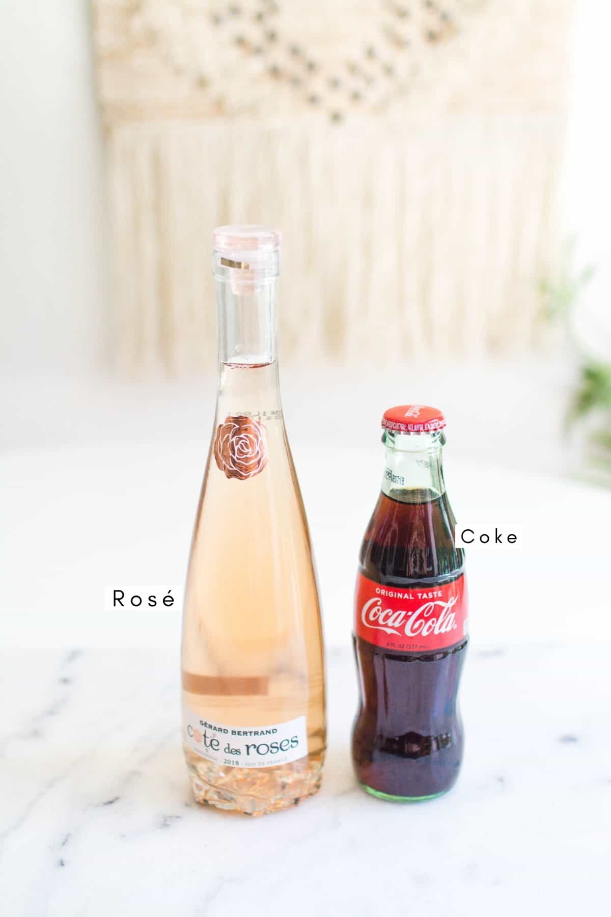 Labeled photo with a small bottle of coke and a mini bottle of rosé.