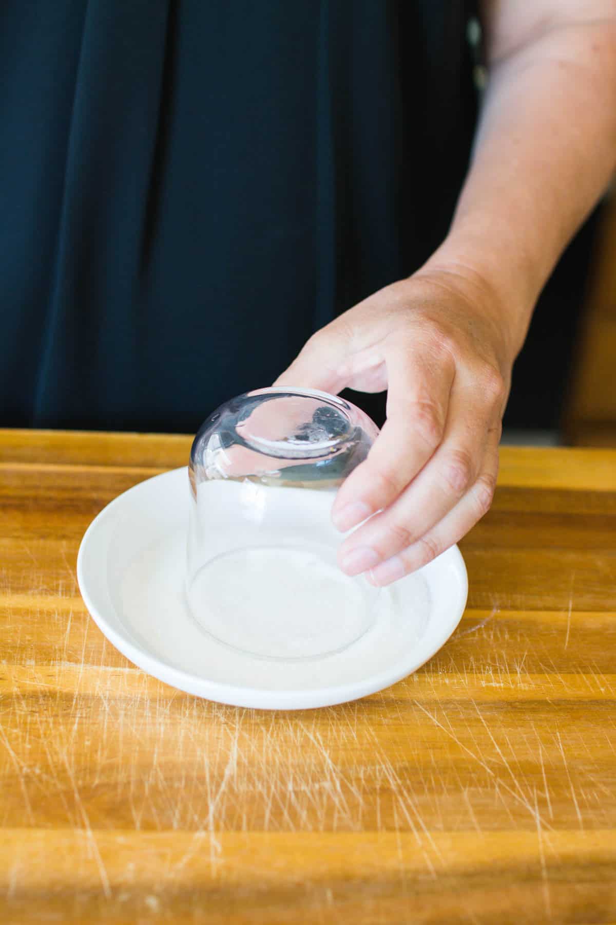 Dipping the rim of the glass into sugar for a cocktail. 