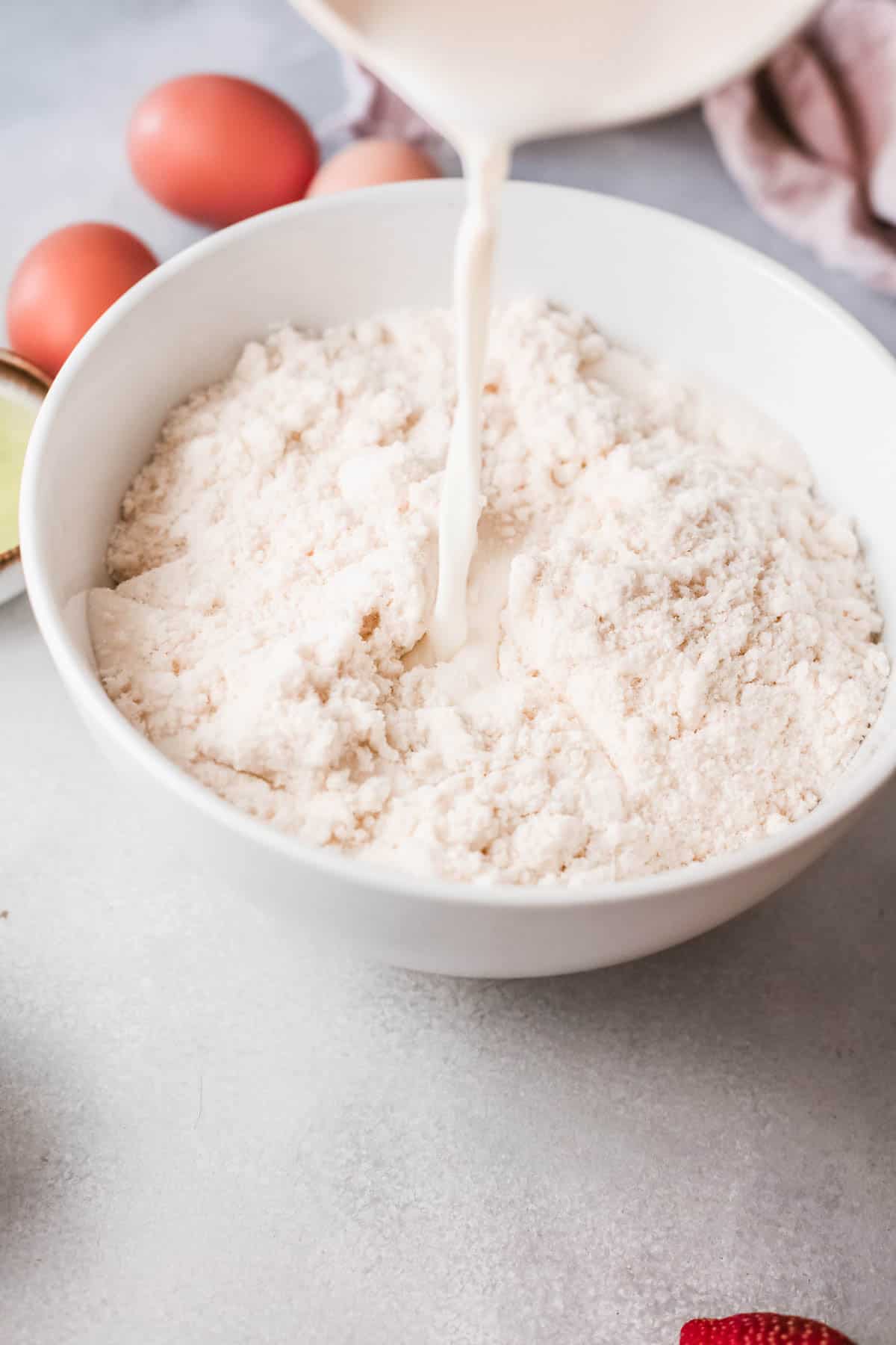 A bowl of dry cake mix with milk being added. 