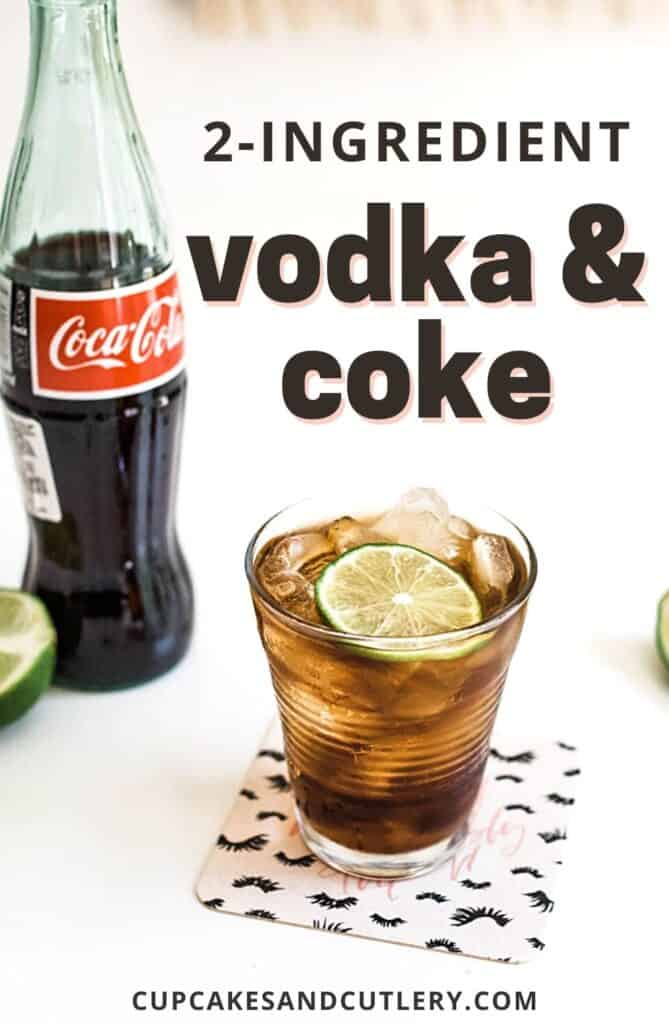A cocktail glass on a table with coke and vodka next to a bottle of Coke.