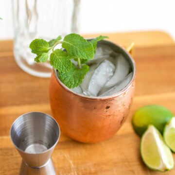 A copper mug with a classic Moscow Mule cocktail garnished with fresh mint.