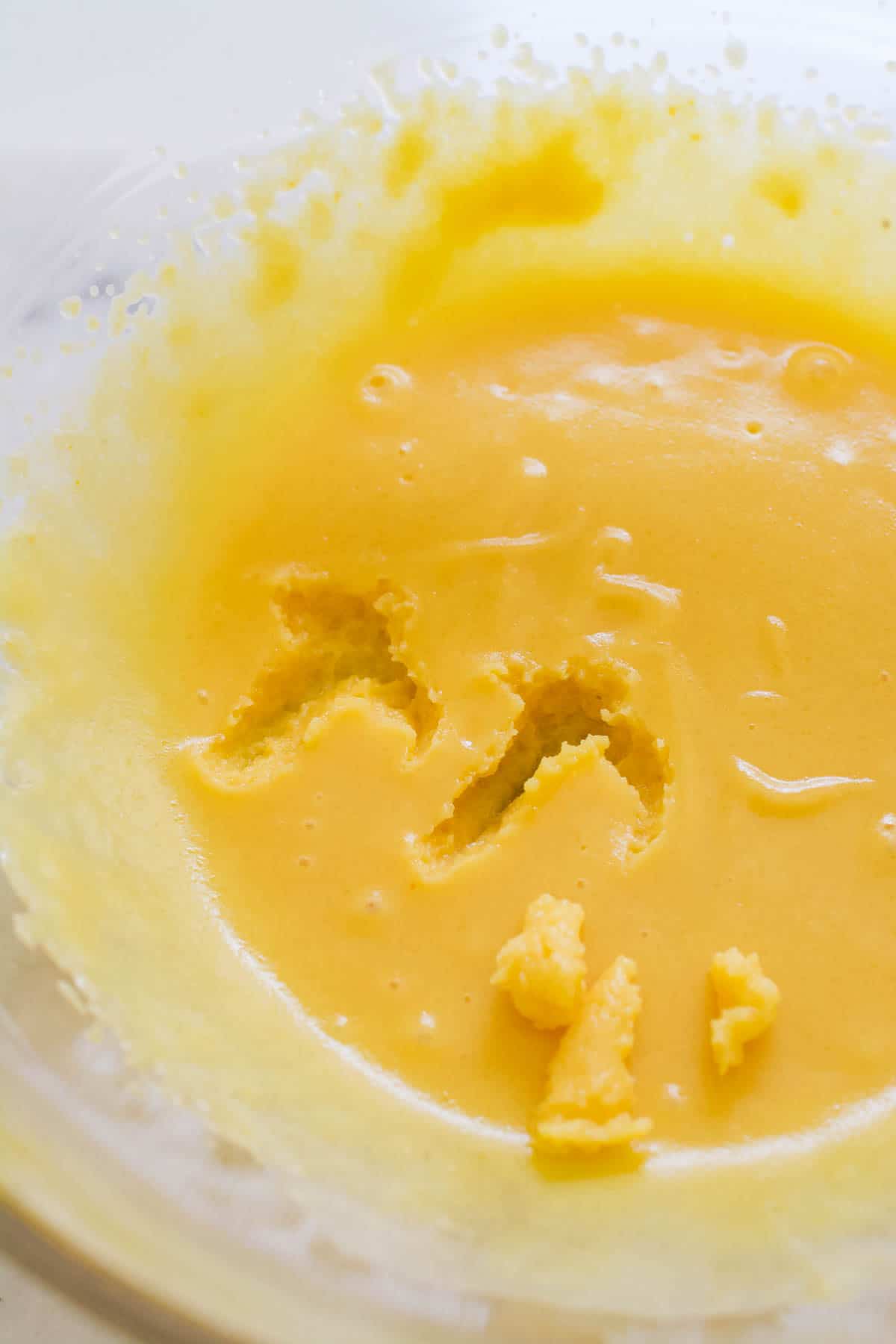 Vanilla pudding and milk that has been set up in a bowl to make Cool Whip Frosting.