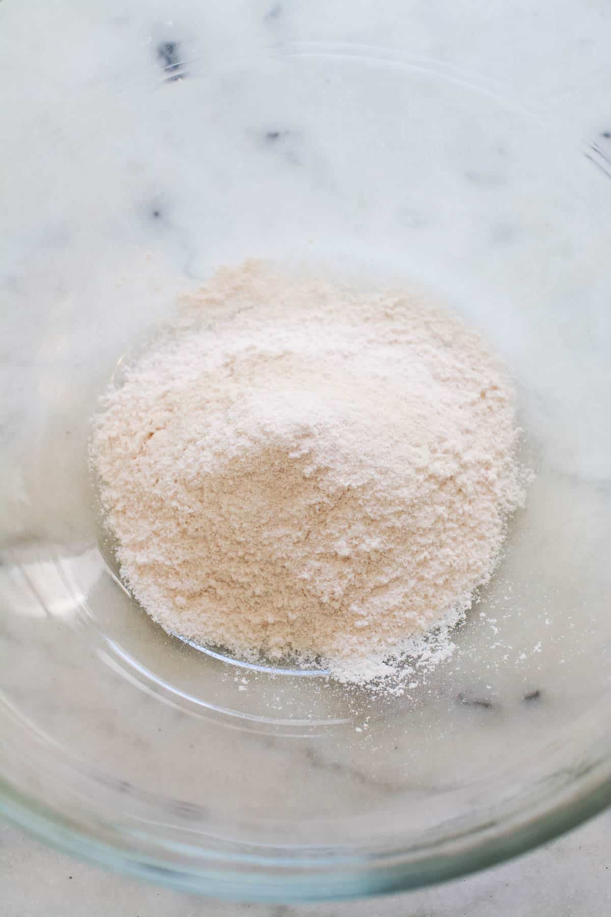 Dry vanilla pudding powder in a large glass mixing bowl. 