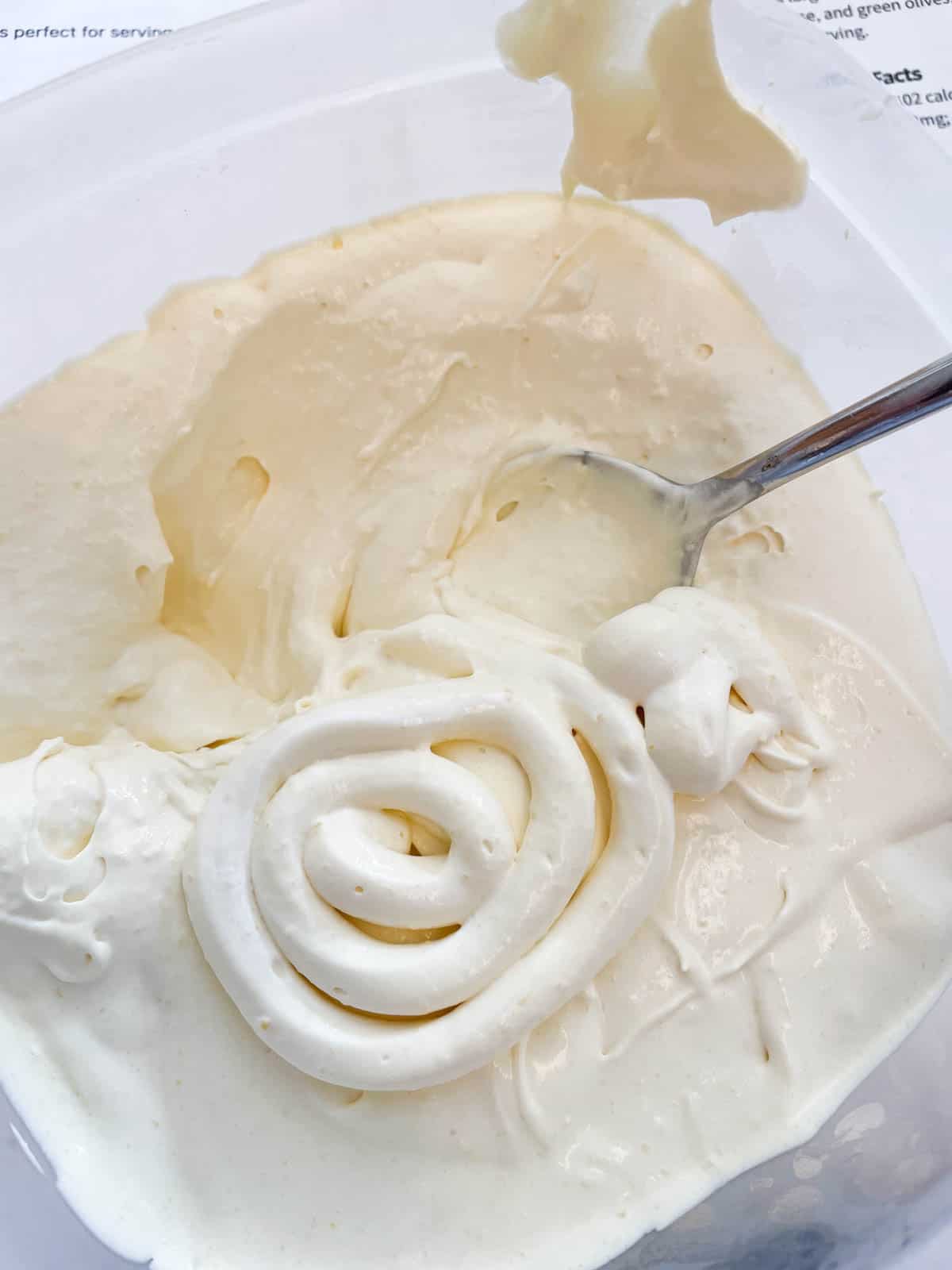 Piped spiral of Cool Whip Frosting in a bowl of frosting.