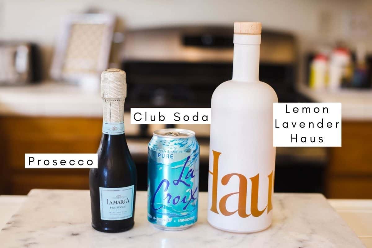 Labeled ingredients to make Haus Spritz cocktail with sparkling water and prosecco.