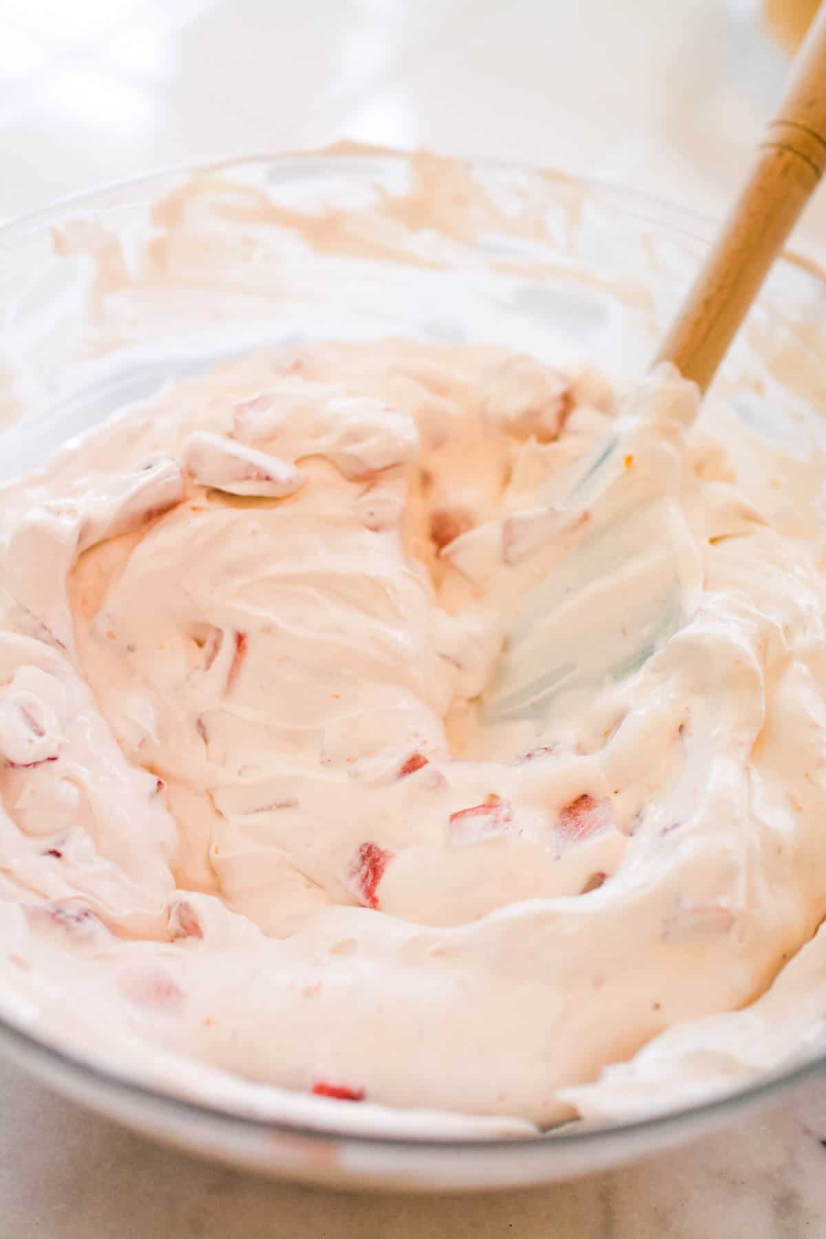 Mixing in the chopped strawberries to the simple strawberry pie recipe. 