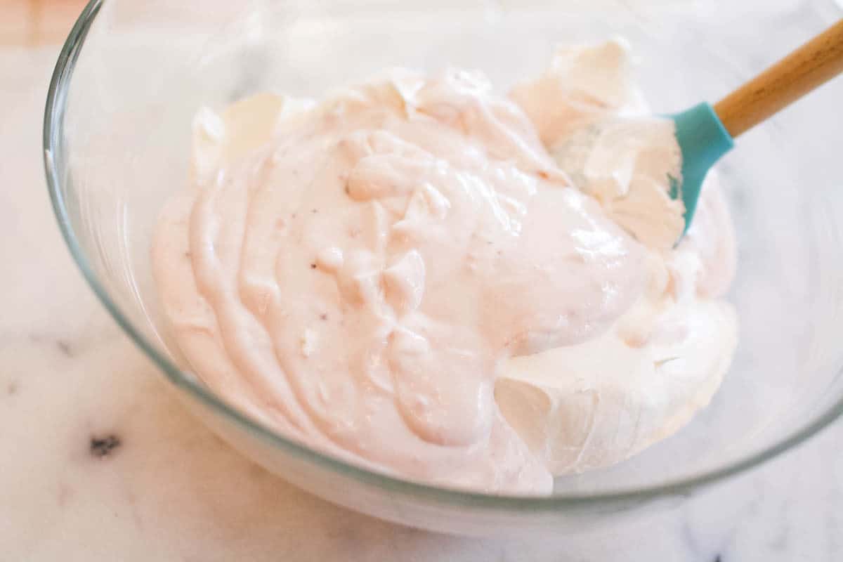 Mixing together the yogurt and the whipped cream for the strawberry pie filling. 