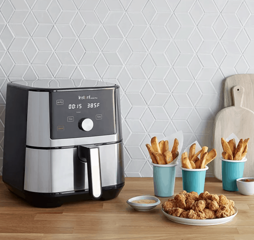 Instant Pot Air Fryer on a table next to some food. 