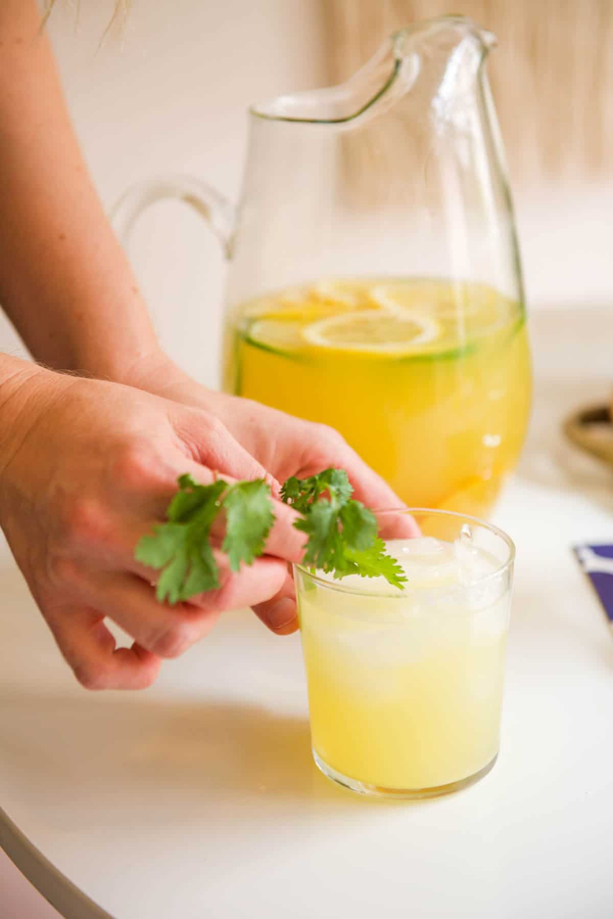 Adding a sprig of fresh cilantro as garnish on the margarita. 