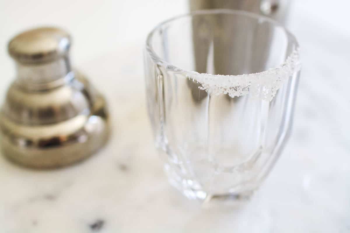 Adding salt to the rim of the cocktail glass.