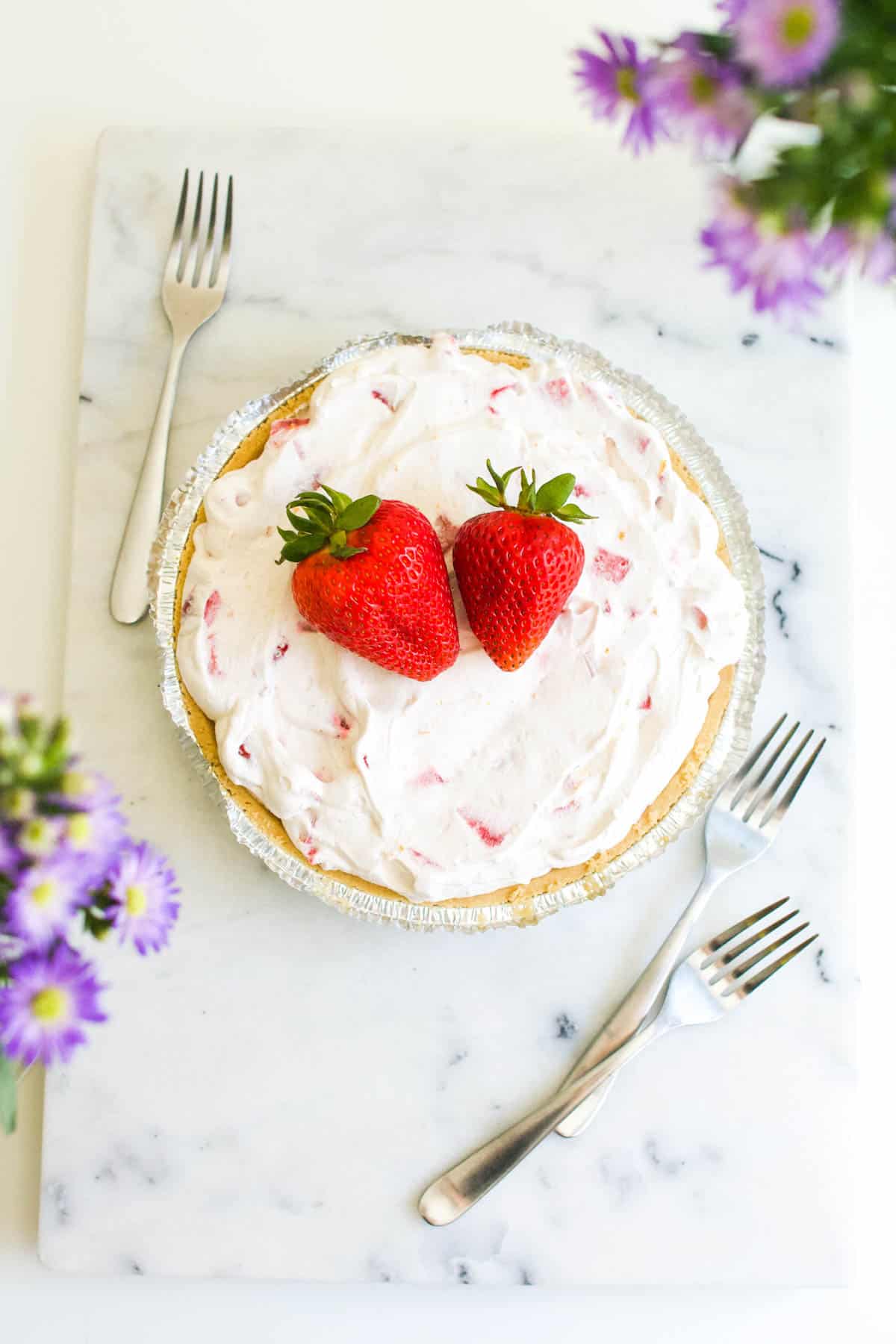 Strawberry Yogurt Pie Recipe on a table, topped with fresh strawberries. 