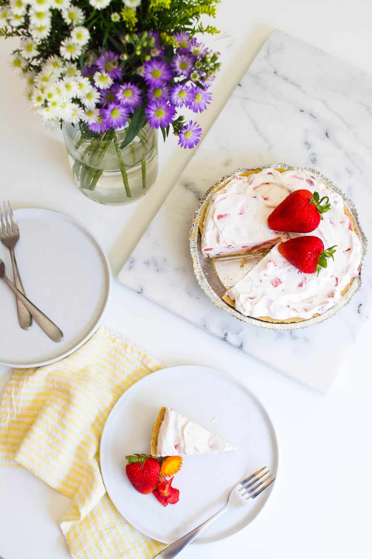 Strawberry Yogurt Pie Recipe with a piece of pie cut out and served on a plate next to it.