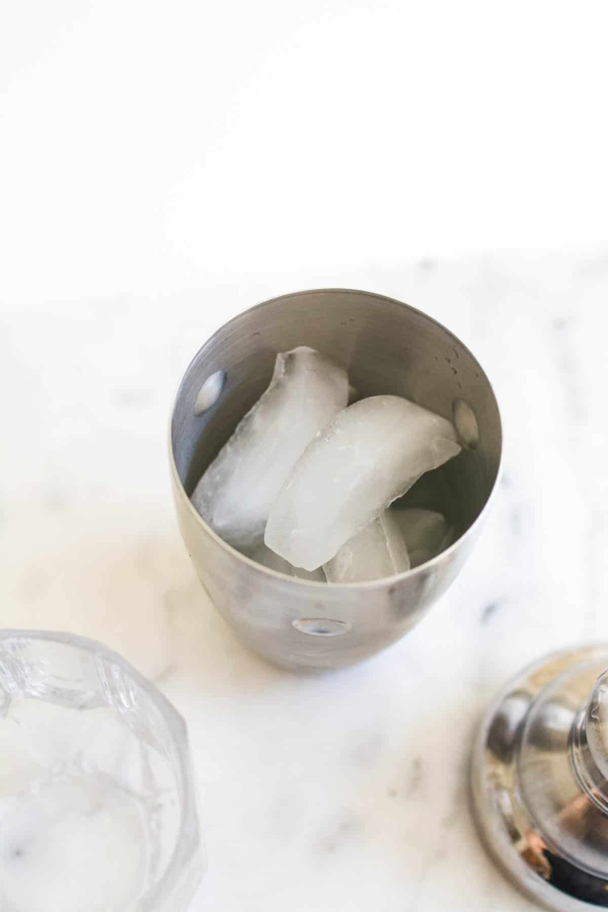 Adding ice to a cocktail shaker.