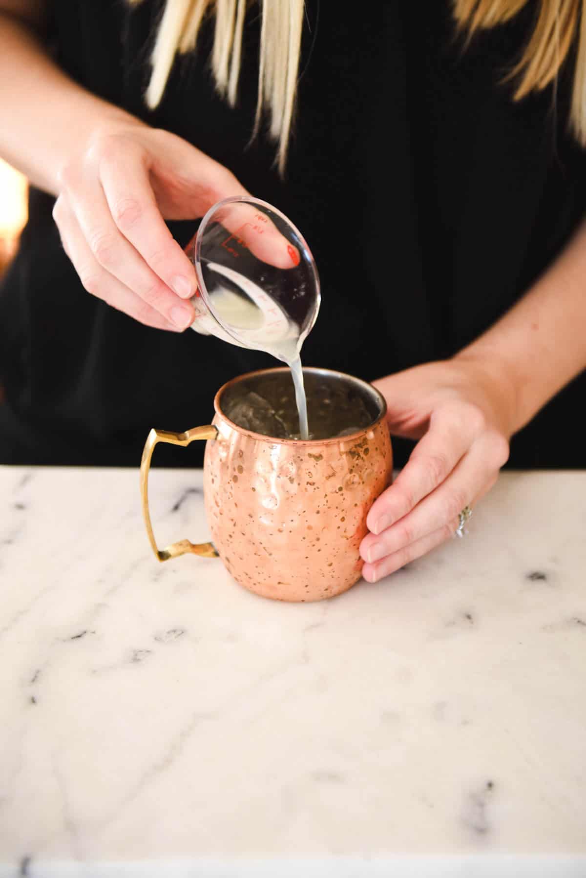 Adding the ginger beer to the copper mug to make the Blueberry Moscow 
 Mule Recipe. 