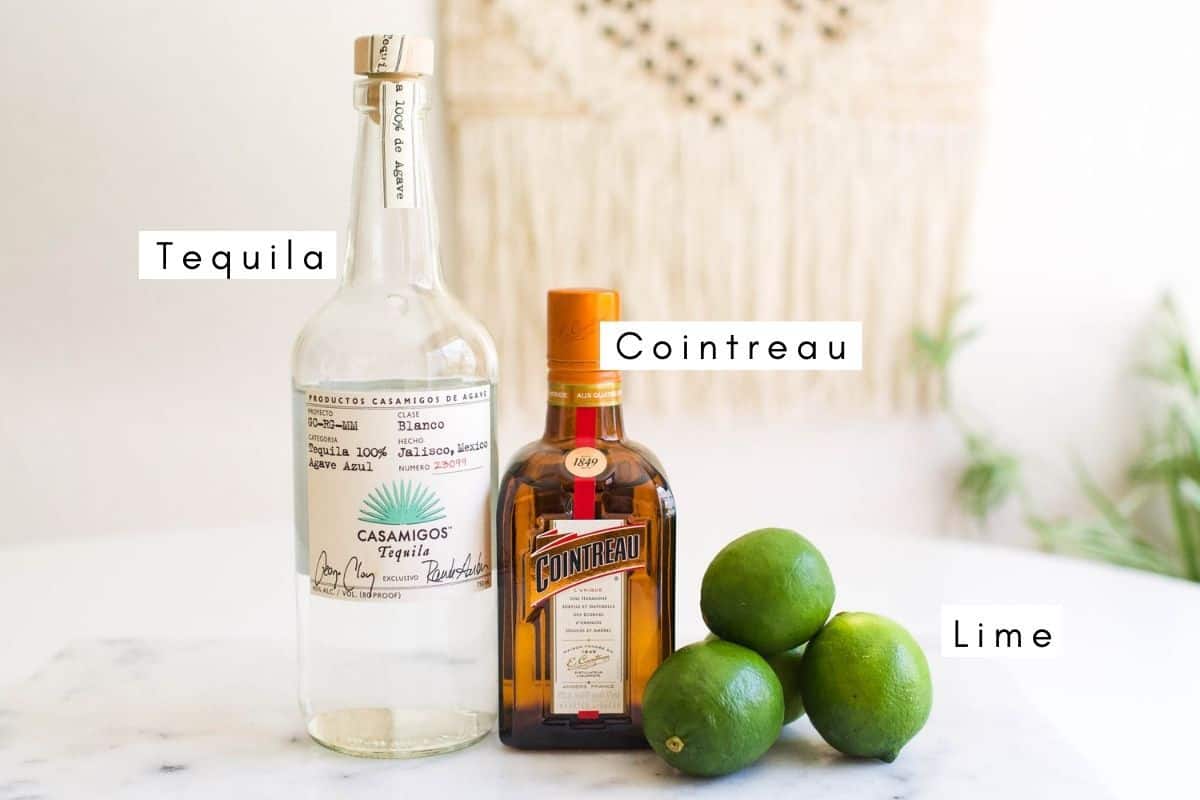 Labeled ingredients on a table to make a classic margarita. 