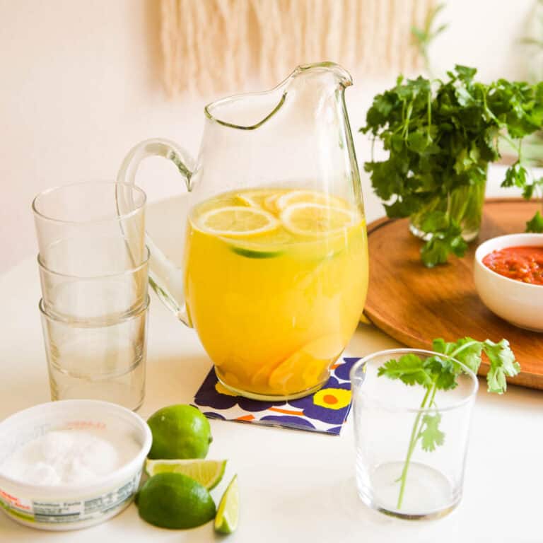 Pitcher of Margarita Sangria recipe with empty glasses, waiting to be poured.