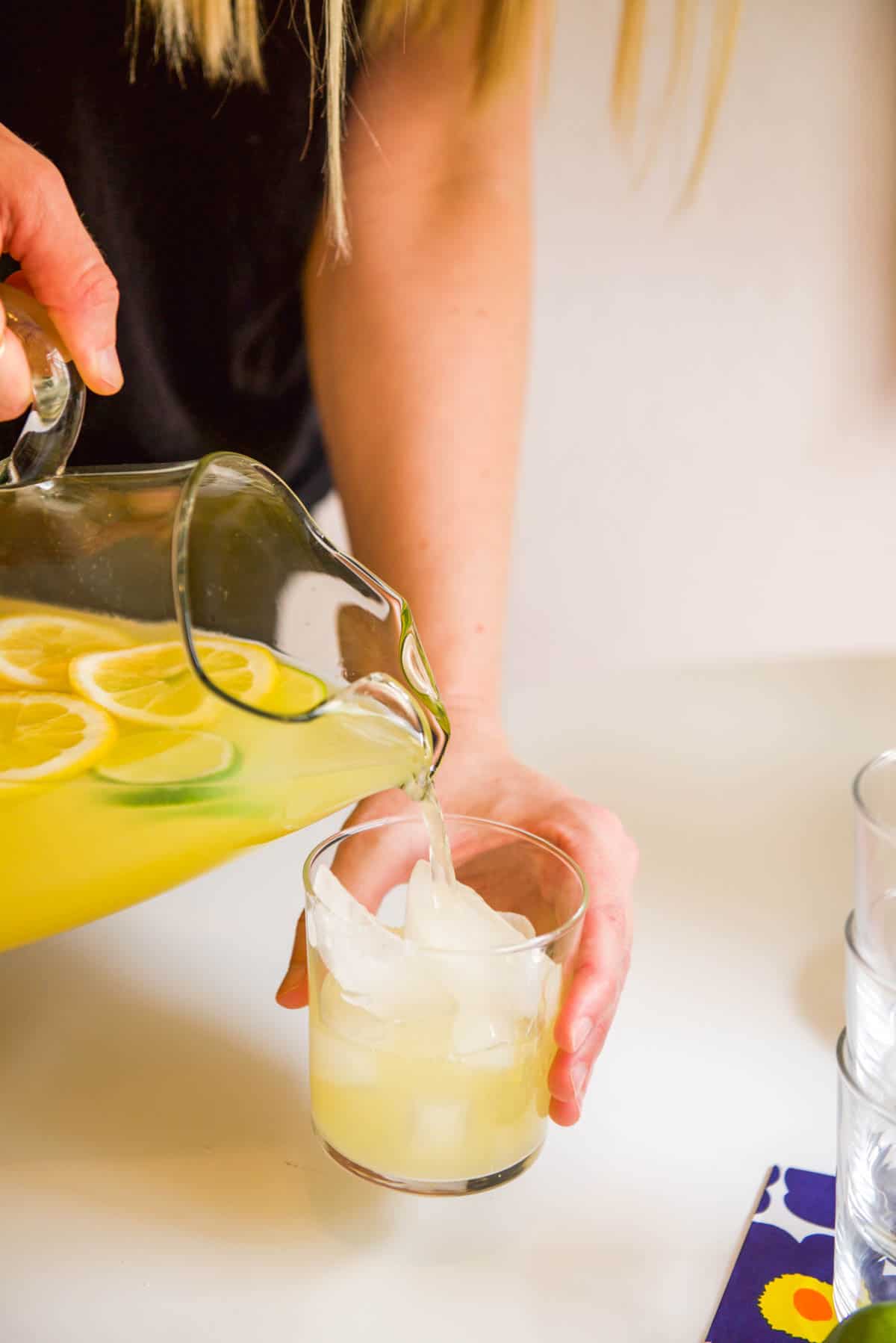 Pouring a pitcher or margarita over ice in a cup. 