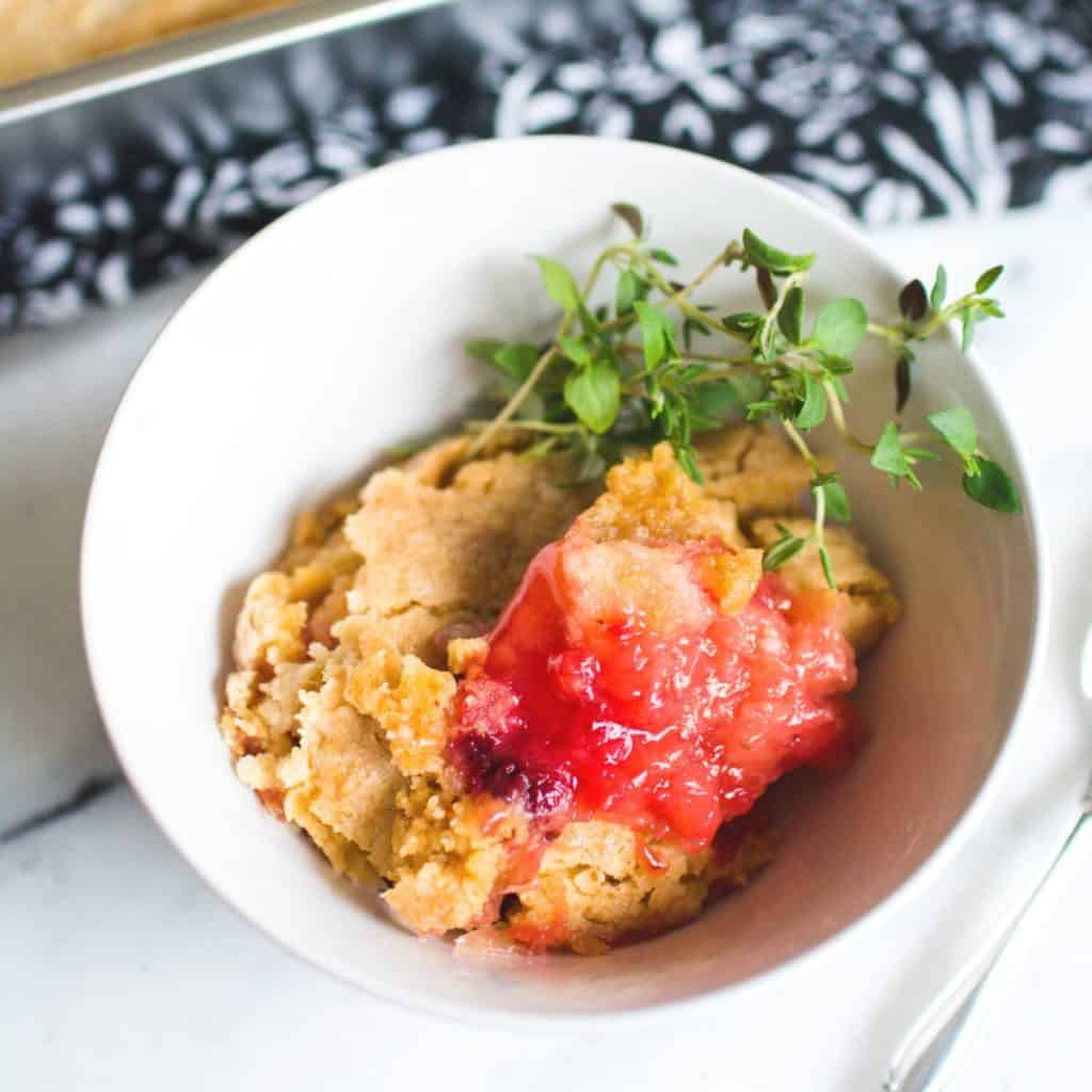 Close up of Strawberry Pineapple Dump Cake in a white dessert bowl.