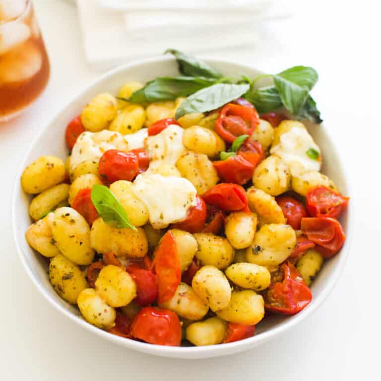 Close up of caprese gnocchi bake in a bowl on the table.