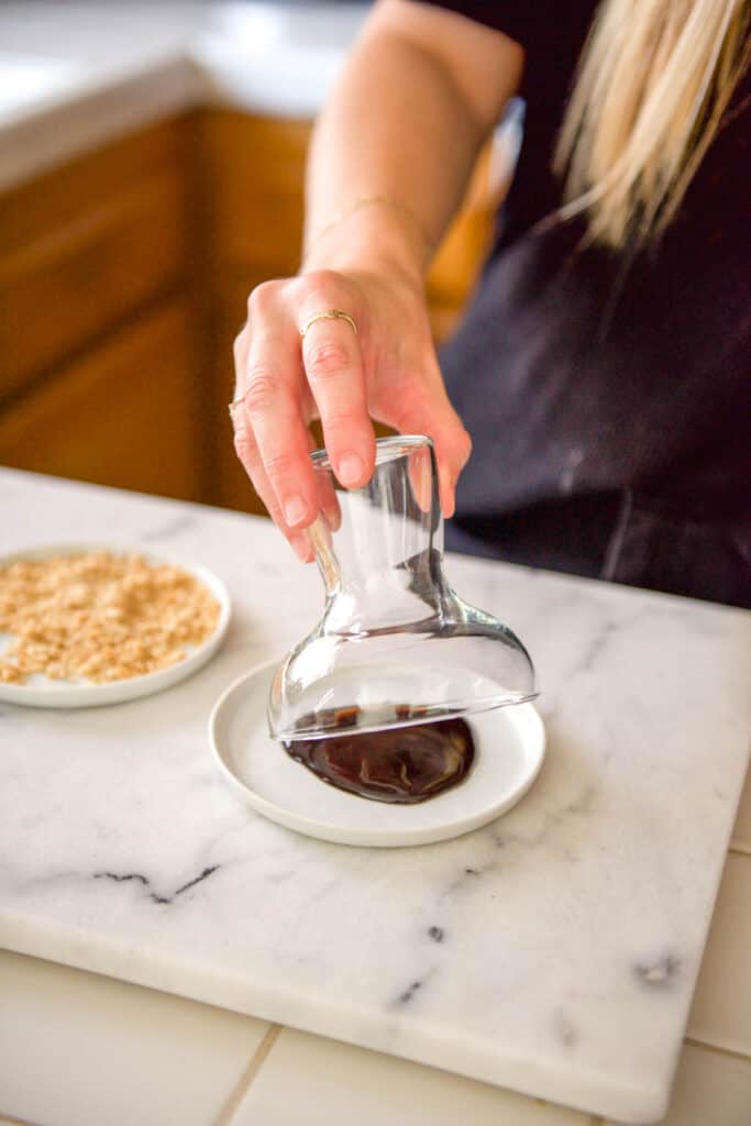 Dipping the edge of a cocktail glass in chocolate syrup.
