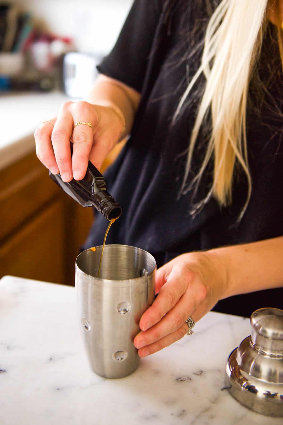 Adding vanilla to a cocktail shaker.