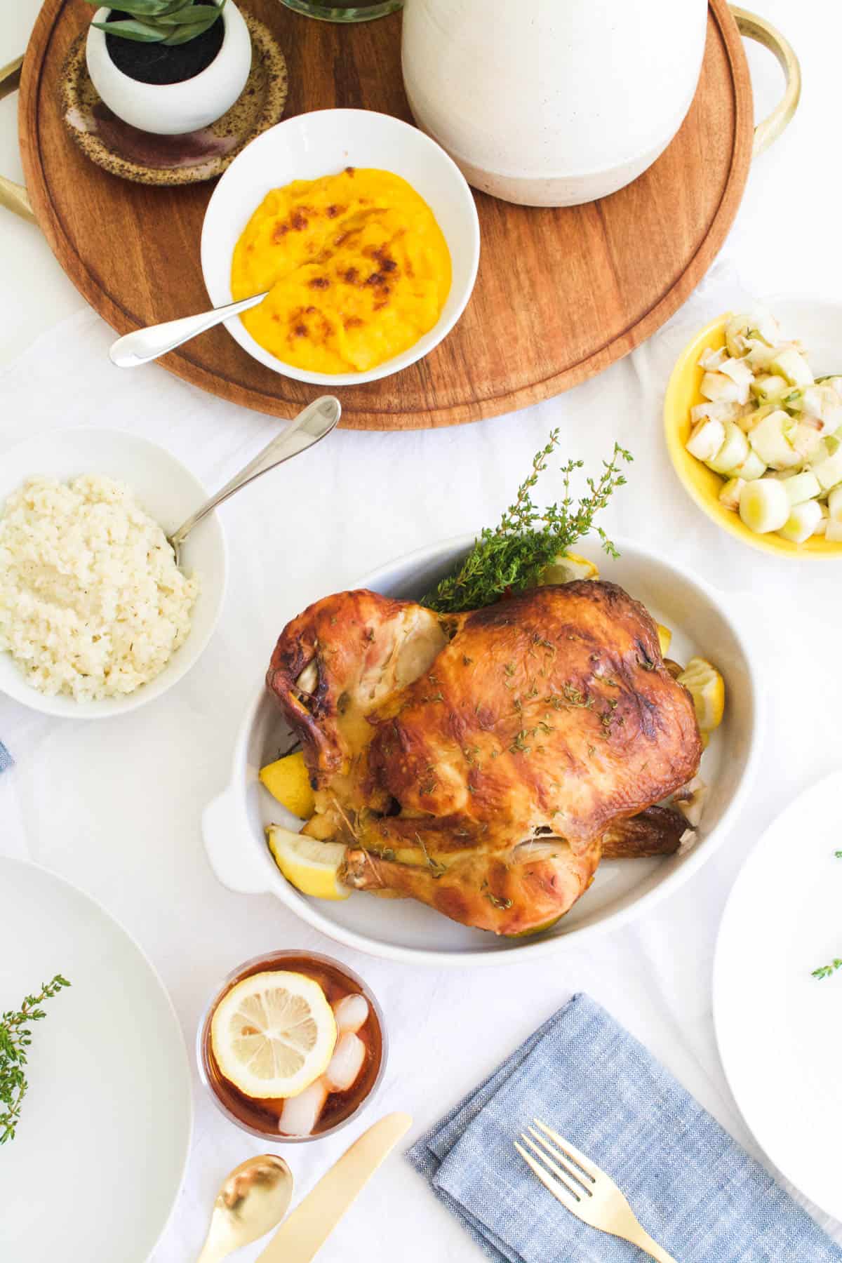 jazzed up store-bought rotisserie chicken on a table with side dishes next to it.