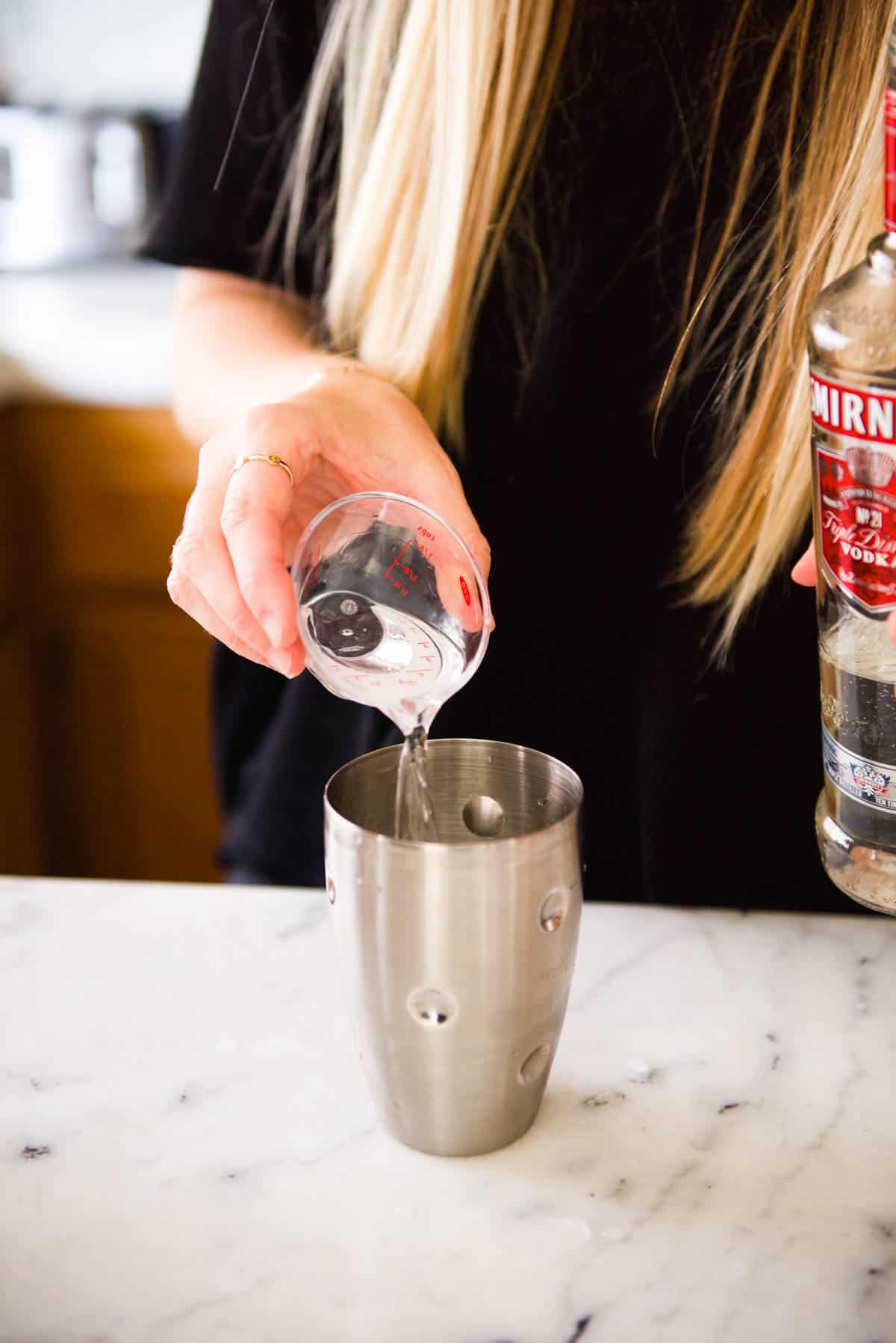 Pouring vodka into a cocktail shaker.