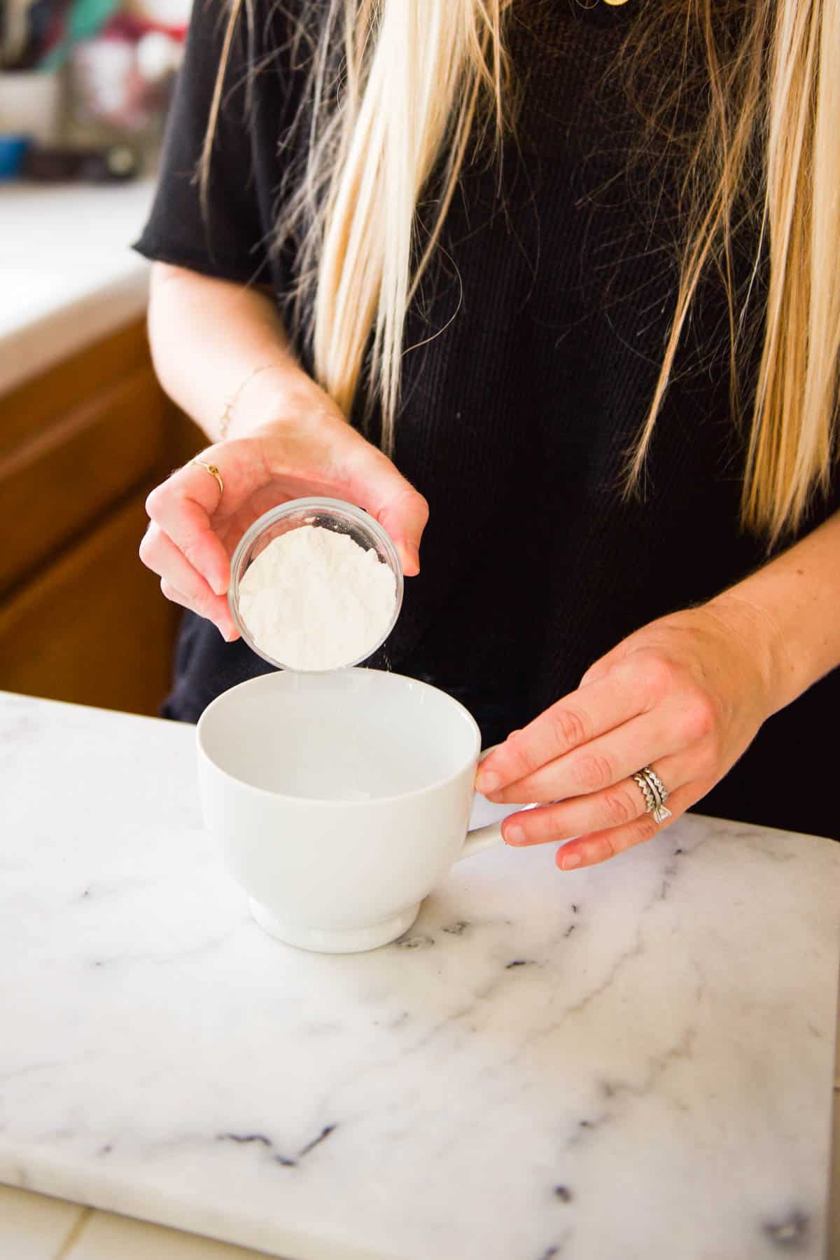 Adding flour to a mug for a dessert for one.