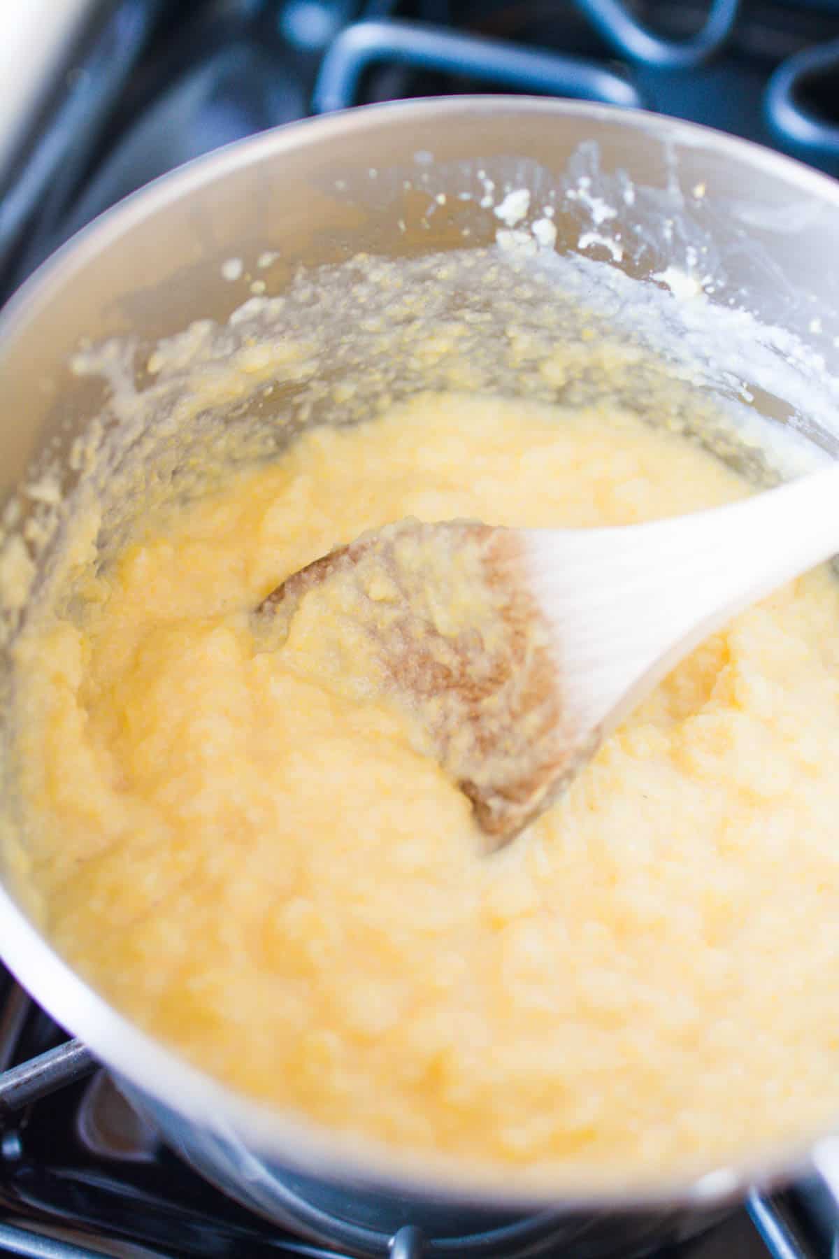 Creamy polenta in a saucepan on the stove.
