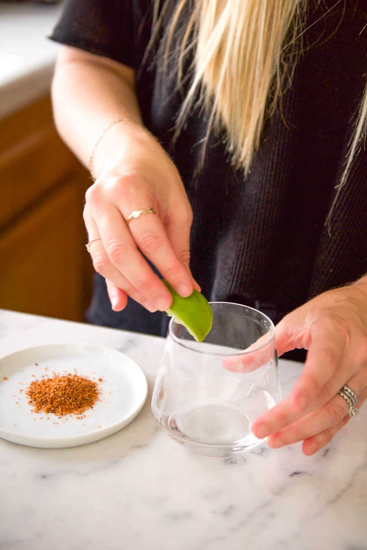 Rubbing a fresh lime on the rim of a cocktail glass for salt or tajin. How to Rim a Cocktail Glass! This post share 3 easy ways to prepare a glass for all kinds of cocktails. With sugar, salt, tajin or even chocolate sauce, this tutorial will show you how!