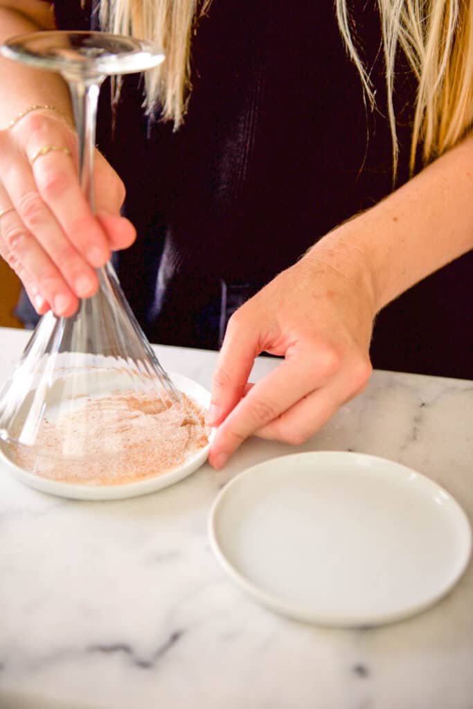 Dipping a martini glass in sugar.