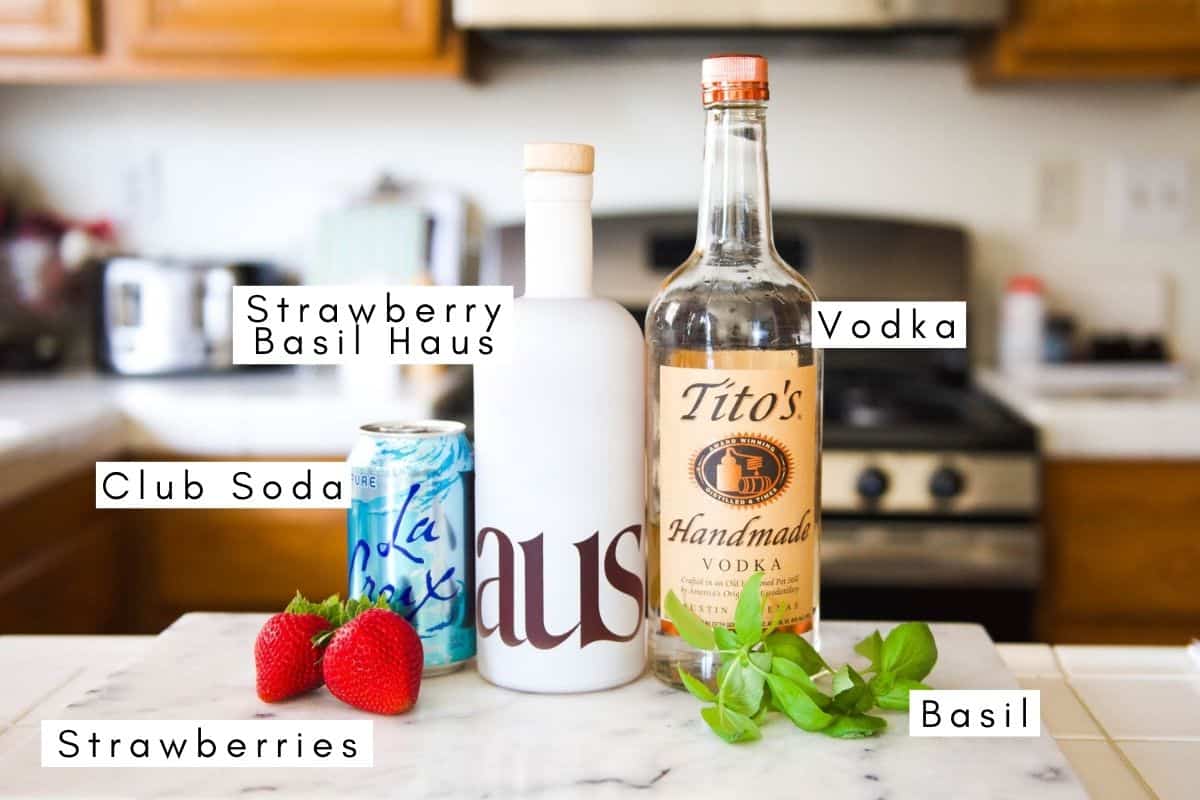 Labeled ingredients on a counter to make a strawberry basil cocktail.