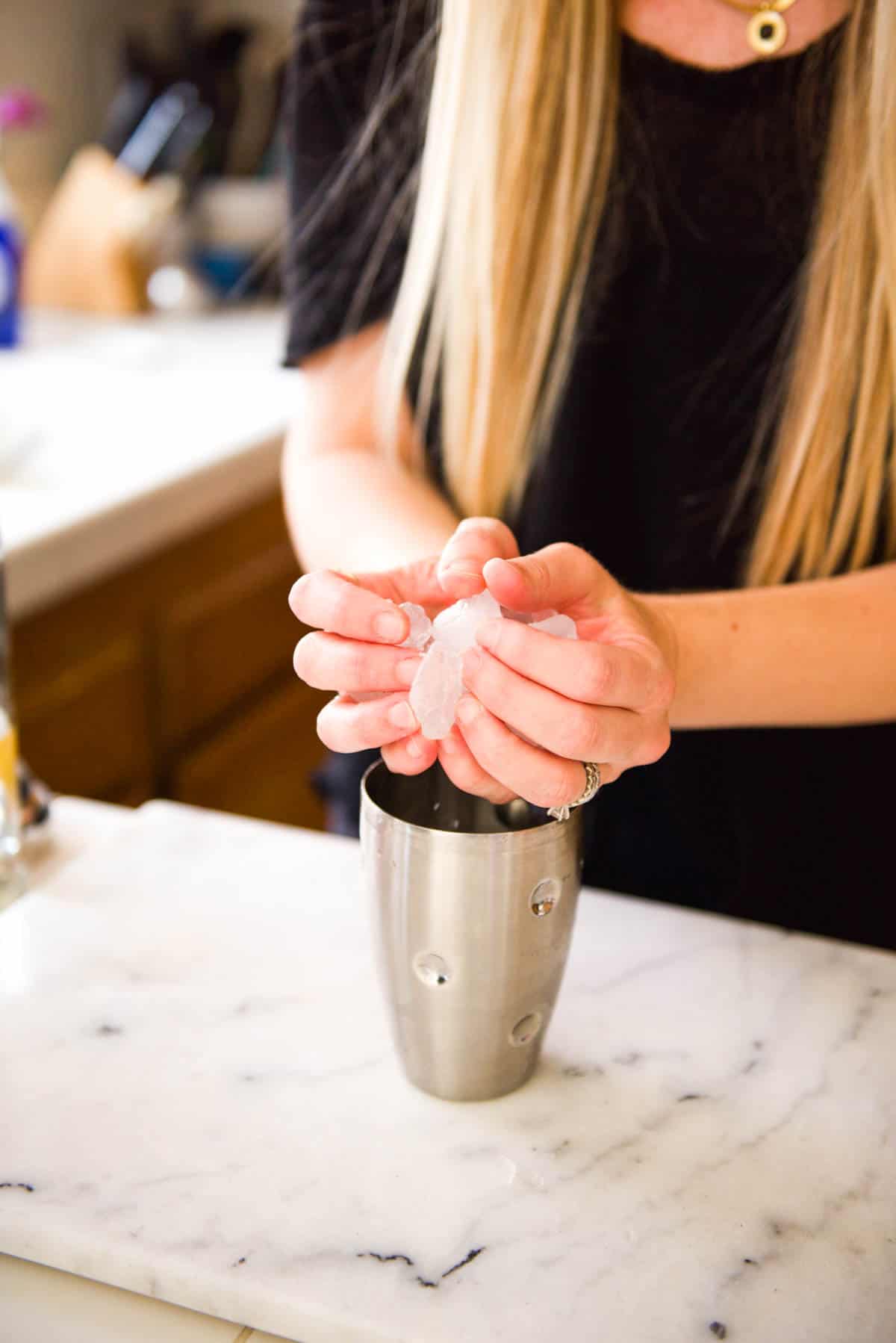 Adding ice to a cocktail shaker.