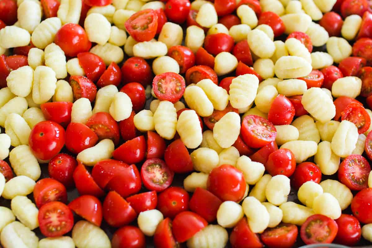 Cherry tomatoes and gnocchi on a sheet pan.