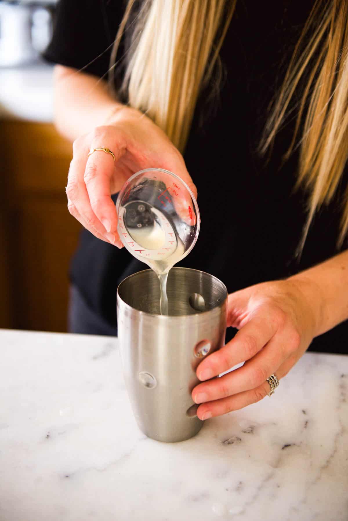 Adding lemon juice to a cocktail shaker.