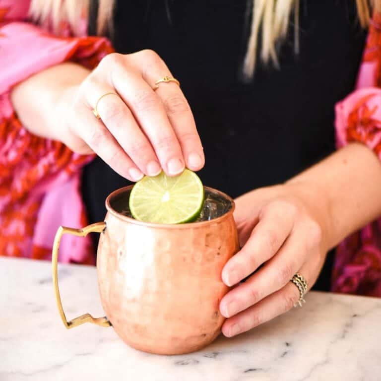 Woman adding a lime to a Mexican Mule.