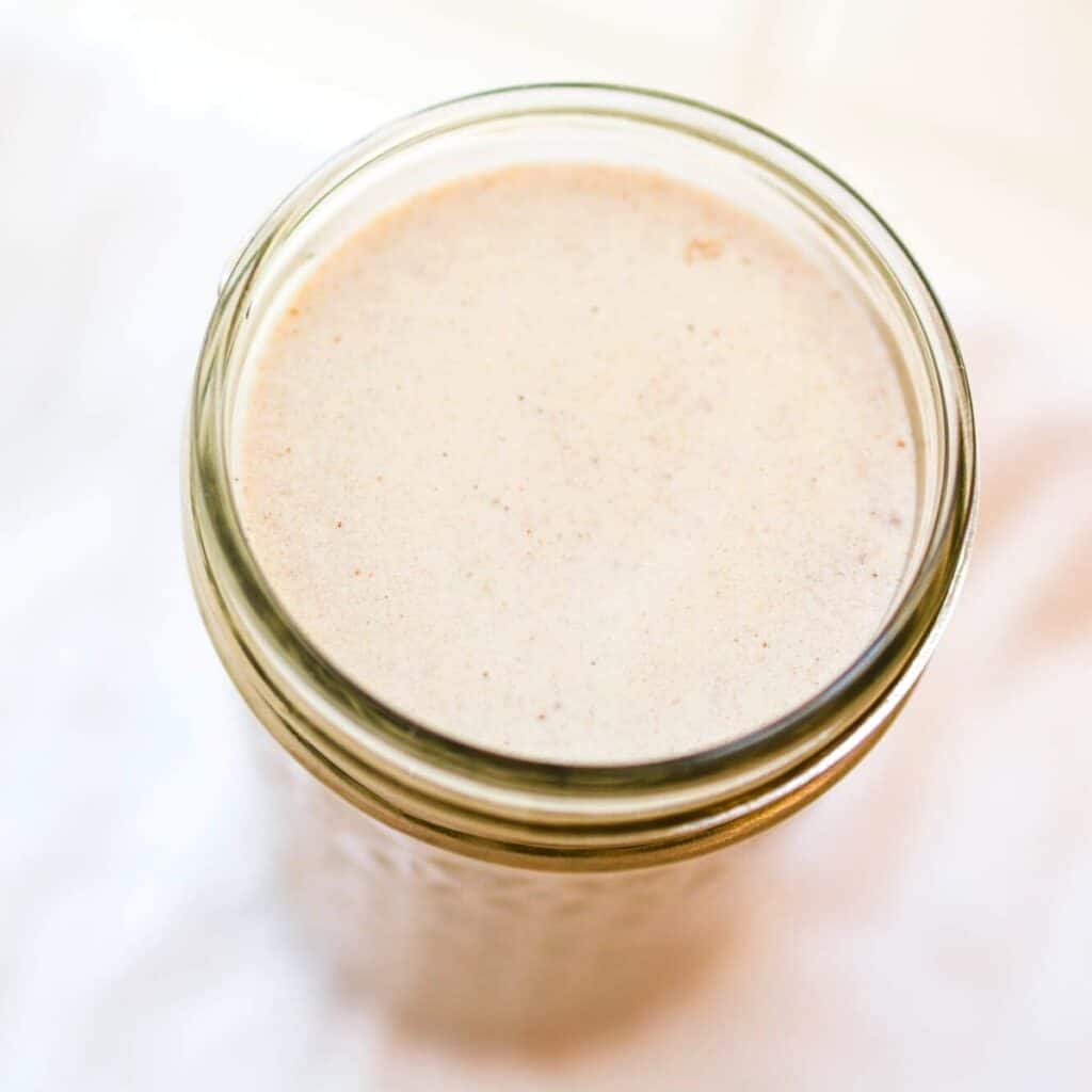 Top down view of homemade cinnamon coffee creamer in a mason jar.