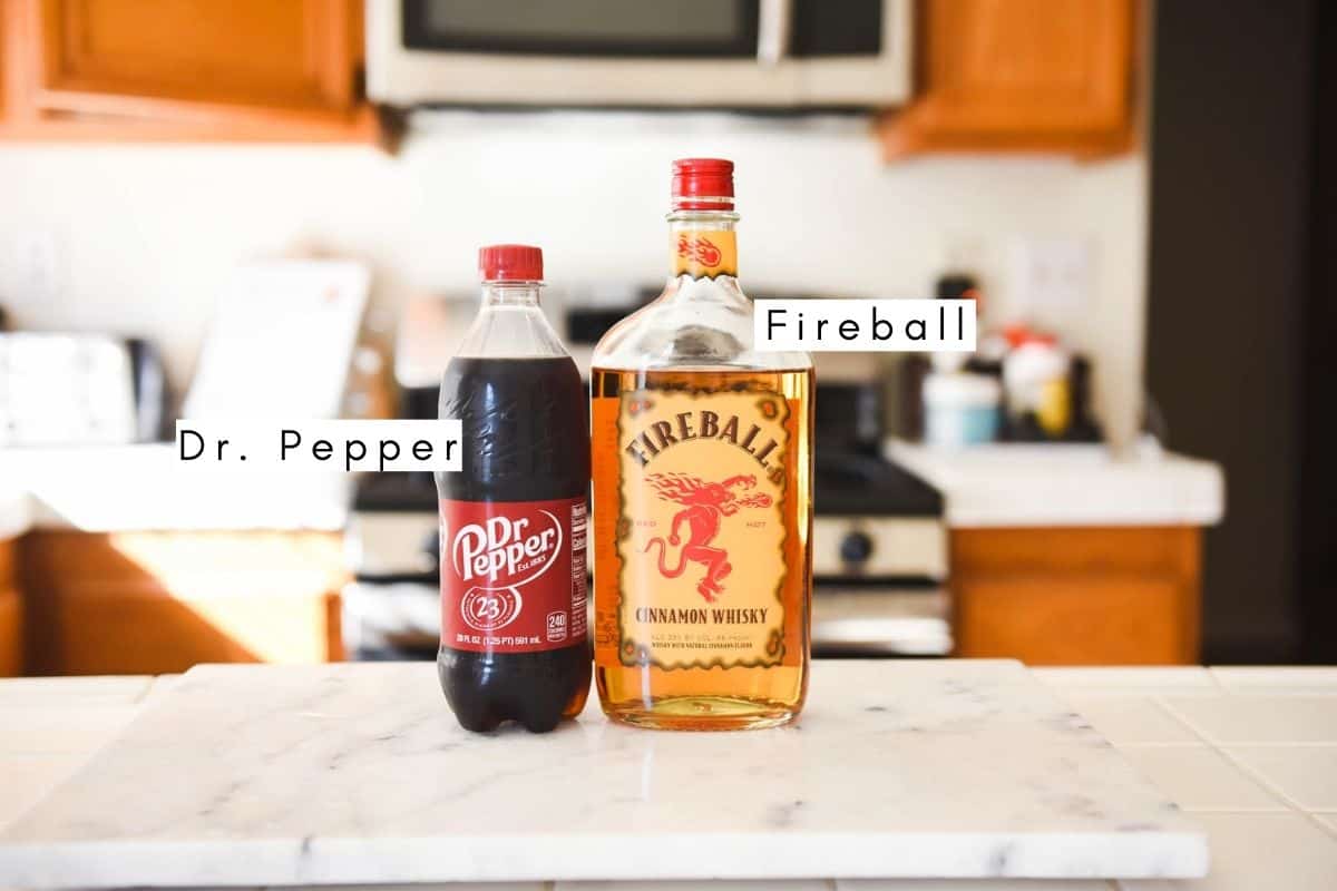 Labeled ingredients to make a cocktail with Dr. Pepper and Fireball cinnamon whiskey.