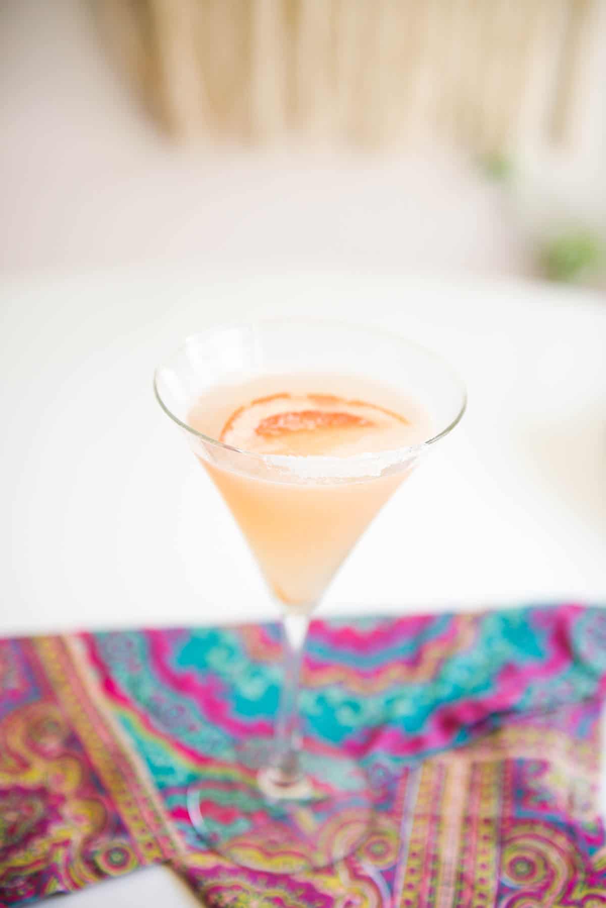 Vodka martini with grapefruit juice in a martini glass on a table.