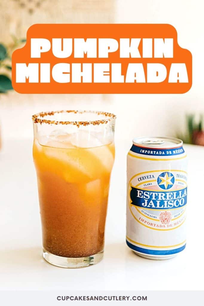 Beer glass of pumpkin michelada with a can of beer next to it on a white surface.