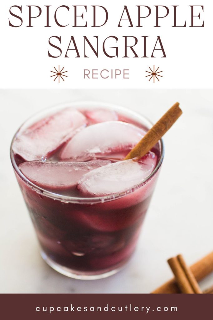 Glass of sangria with ice cubes garnished with a cinnamon stick.