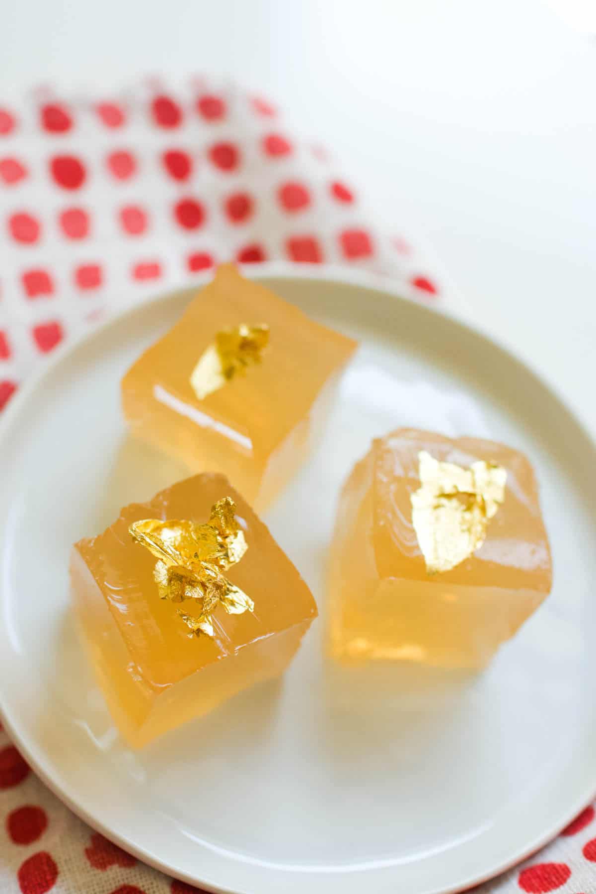 Pretty Sauvignon Blanc Jello Shots on a small white plate topped with edible gold leaf.