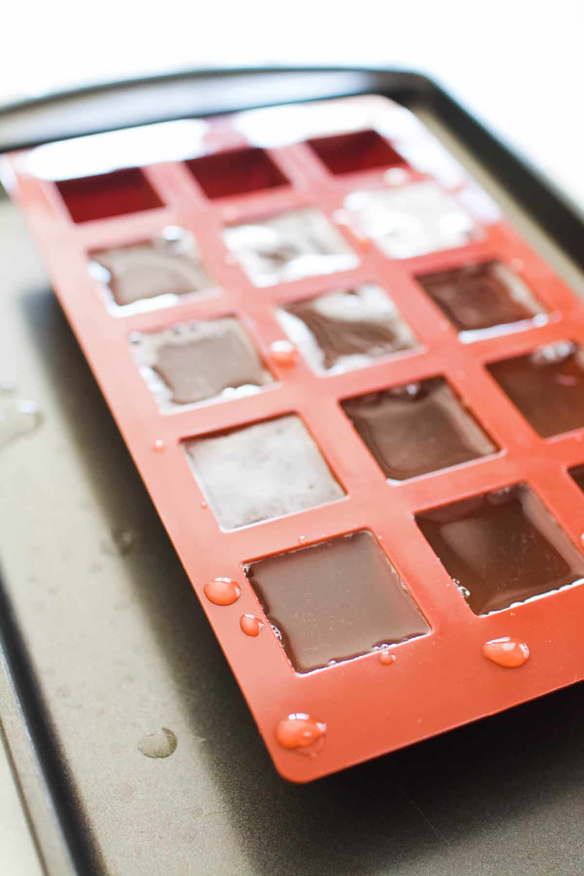 Jello shots with wine being made in a red silicon baking mold.