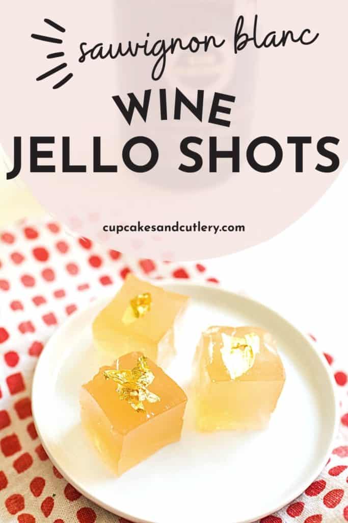 A small white plate with 3 square pieces of Jello spiked with sauvignon blanc with text that says "sauvignon blanc wine jello shots".