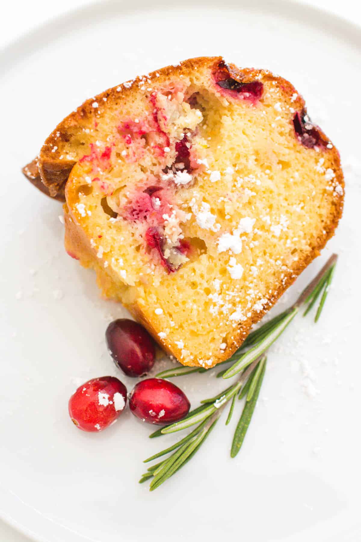 A slice of cranberry bundt cake on a white dessert plate.