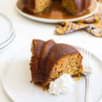 Close up of a slice of bourbon cake and whipped cream.