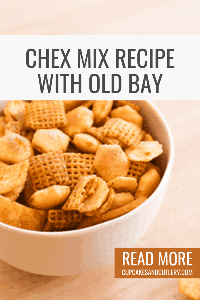 Text- Check Mix Recipe with Old Bay with a bowl of cereal snack mix on a wooden table.