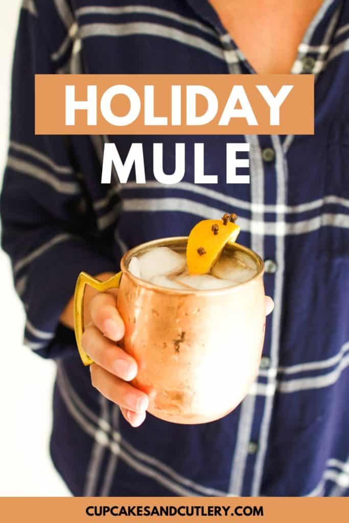 Woman holding a Holiday Moscow Mule in a copper mug.